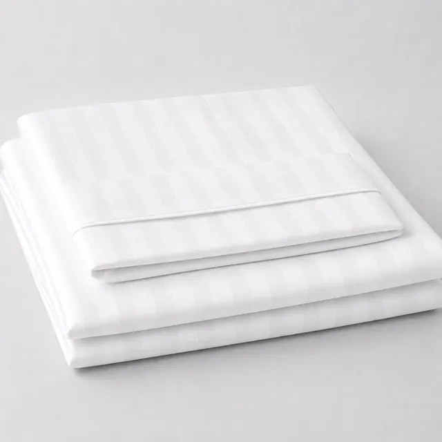 Folded white striped hospital bed sheets